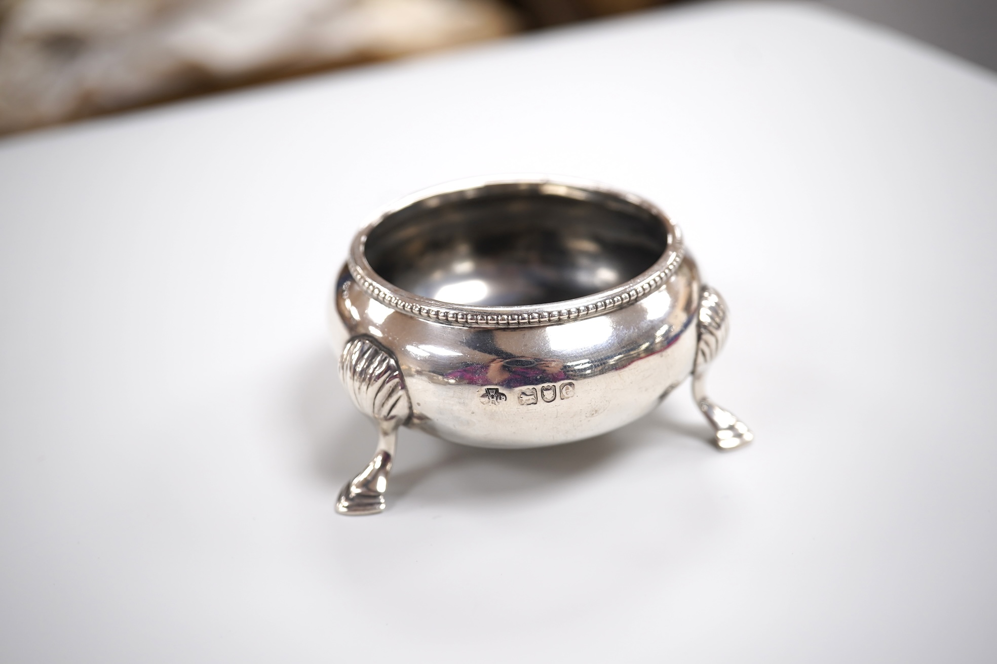 A group of small silver including a modern mounted wine coaster by M C Hersey & Son Ltd, diameter 12.6cm, a set of three George V nut dishes, one other silver nut dish, two pairs of salts including cauldron by William Hu